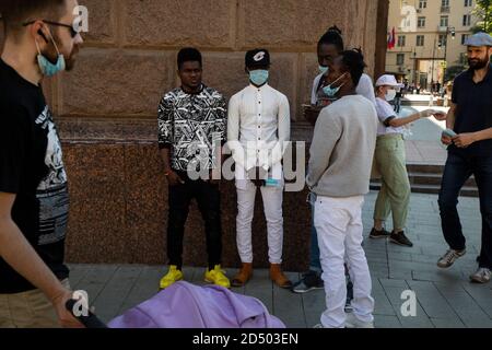Moskau, Russland. 24. Juni 2020 Afrikaner mit Schutzmaske gehen während der Pandemie des neuartigen Coronavirus COVID-19 in Russland auf der zentralen Straße von Moskau Stockfoto