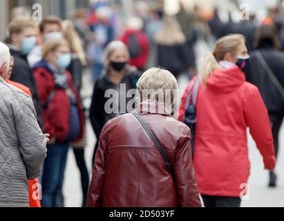 Düsseldorf, Deutschland. Oktober 2020. Passanten mit und ohne Mund-Nase-Schutz gehen durch eine Einkaufsstraße. In vielen Großstädten in Nordrhein-Westfalen ist die Zahl der neuen Coronainfektionen pro 100,000 Einwohner innerhalb einer Woche über die entscheidende Schwelle von 50 gestiegen. Quelle: Roland Weihrauch/dpa/Alamy Live News Stockfoto