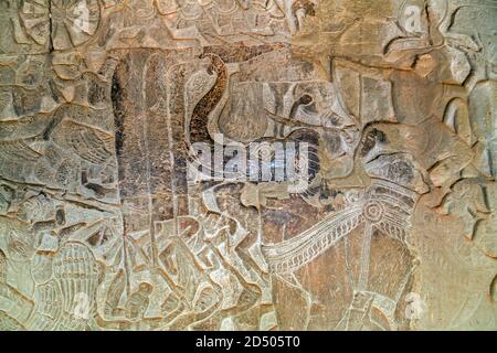 Khmer Bas-Relief Schnitzwerk von Göttern, die Dämonen bekämpfen. Innenwand des Tempels von Angkor Wat, Siem Reap, Kambodscha. Stockfoto