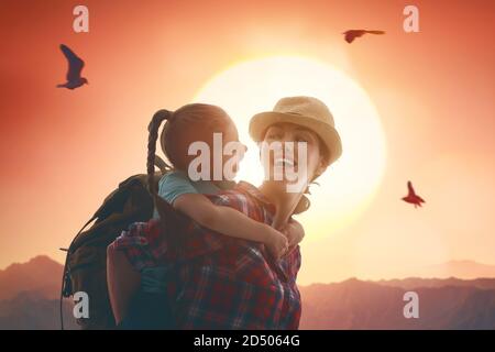 Zwei Reisende bei Sonnenuntergang. Mutter und Kind Tochter Mädchen haben Spaß und genießen Reise. Stockfoto