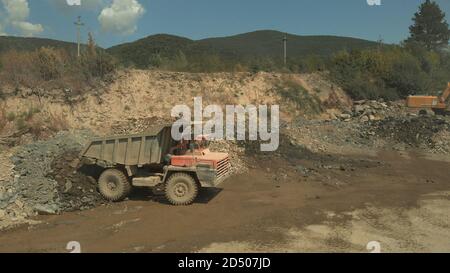 Großer orangefarbener staubiger LKW. Stockfoto