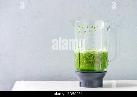 Grüne Spinat kale apple Smoothie in Glas Mixer auf weißem Marmortisch. Gesunde organische Essen. Stockfoto
