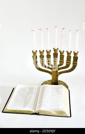 Menorah und offene Bibel mit 7 nicht leuchtende Kerzen auf weißem Hintergrund. Vertikale erschossen. Kopieren Sie Platz. Stockfoto