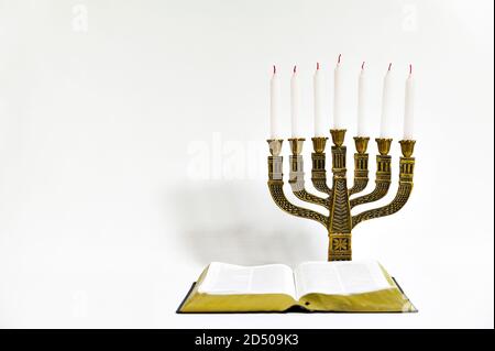 Menorah und offene Bibel mit 7 nicht leuchtende Kerzen auf weißem Hintergrund. Kopieren Sie Platz. Horizontale erschossen. Stockfoto