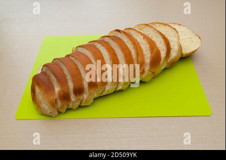 Köstliche hausgemachte brasilianische Brot in Scheiben geschnitten. Isoliert auf beigefarbenem Holzhintergrund. Stockfoto