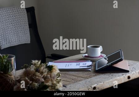 Gemütliches Heimbüro mit einem Schreibtisch aus wiedergewonnenem Holz in Farbtönen Aus Creme und Rosa Stockfoto