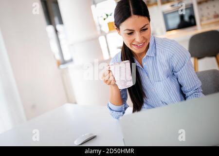 Frau mit Notebook in der Küche. Arbeiten von zu Hause aus in Quarantänesperre. Soziale Distanzierung Stockfoto