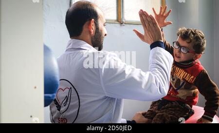 Eine Krankenschwester spielt mit einem kranken Kind. Stockfoto