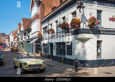 Traditionelle britische Landschaft, Blick im Sommer auf einen MG-Sportwagen, der an einem Pub in Winchester, Hampshire, England, Großbritannien, vorbeigefahren wird Stockfoto