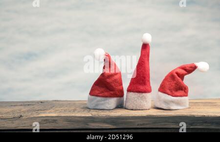 Drei Hut von Santa auf einem Holzbrett mit Platz Für Text Stockfoto