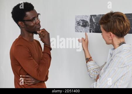 Waist up Porträt von zwei jungen Menschen diskutieren Kunst während der Erkundung der modernen Galerie Ausstellung, Copy Space Stockfoto