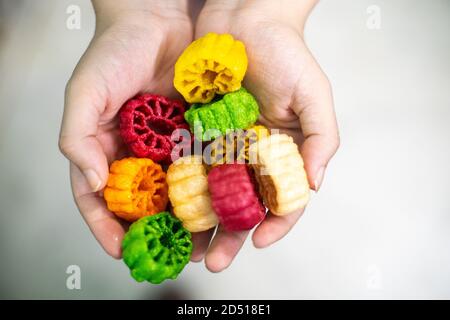 Junge indische Frau hält bunte frittierte Lebensmittel aus Kartoffeln Stärke und Sago genannt Far Far Fryums, das ist ein Beliebtes Essen in nordindien oder eine große Stockfoto