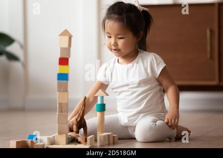 Close up ziemlich kleine asiatische Mädchen spielen Holzwürfel Stockfoto