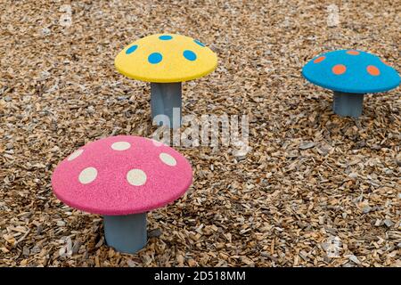 Nahaufnahme von bunten Pilzform Trittsteine Spiel auf einem Kinderspielplatz draußen im Sommer Rot, Rosa, Blau, Orange, Gelb Stockfoto