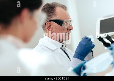 Wissenschaftler setzen auf eine Schutzmaske in einem medizinischen Labor . Stockfoto