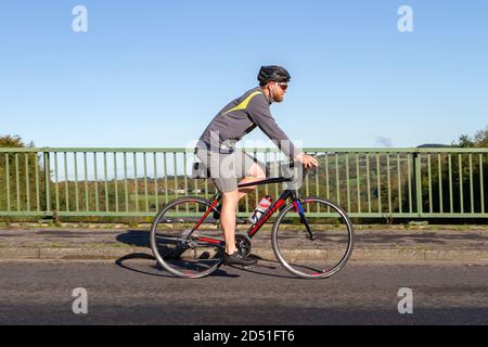 Männlicher Radfahrer Reiten Kohlefaser Sport Rennrad Fahrrad auf dem Land Route über Autobahnbrücke in ländlichen Lancashire, Großbritannien Stockfoto