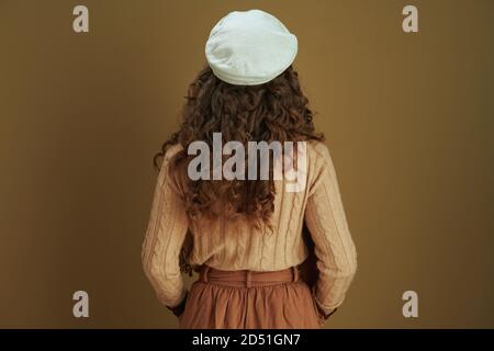 Hallo september. Von hinten gesehen Frau mittleren Alters in Pullover isoliert auf beige. Stockfoto