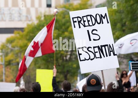 Die Demonstranten erklären, dass "Freiheit unerlässlich" ist, auf dem "March for Freedom" in Toronto, ON, mit dem Ziel, die COVID-19-Beschränkungen zu beenden. Stockfoto