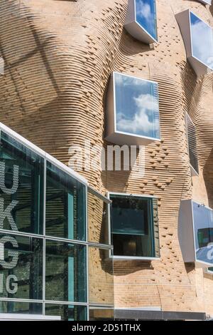 Detailansicht der gewellten Ziegelwand und der Oberseite des verglasten Eingangs. DR Chau Chak Wing Building, UTS Business School, Sydney, Australien. Architekt: Gehry Stockfoto