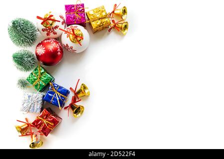 weihnachtliches Hintergrundkonzept. weihnachtsgeschenkkasten und -Baum mit goldenen Glocken, Tannenzapfen, roter und weißer Kugel auf weißem Hintergrund, Blick von oben Stockfoto