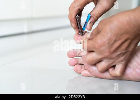 Nagelschneiden, ältere Frau Fuß schneiden Nägel mit Nagelschneider auf weißem Hintergrund, Nahaufnahme Stockfoto