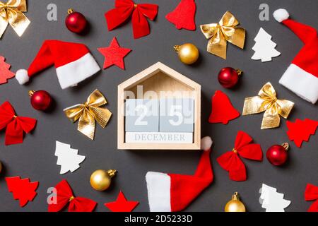 Blick von oben auf die Holz- Kalender auf schwarzen Hintergrund mit neuen Jahr Spielzeuge und Dekorationen. Die Zwanzig 5. Dezember. Weihnachten Konzept. Stockfoto