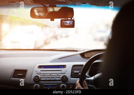 Frontkamera Auto Recorder, Frau fährt ein Auto mit Videorecorder neben einem Rückspiegel Stockfoto