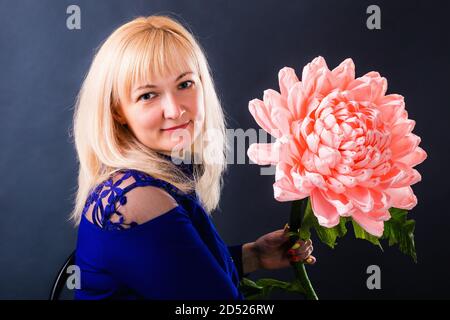 Frau zeigt eine riesige rosa Blume Hand aus Papier. Stockfoto