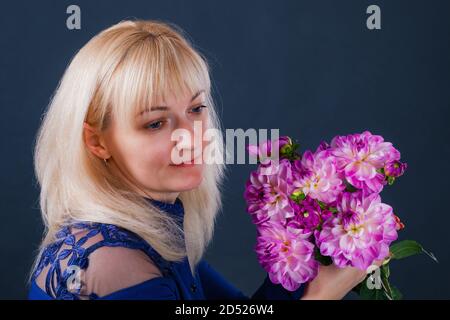 Porträt einer blonden Frau mit Dahlia-Blumen Stockfoto