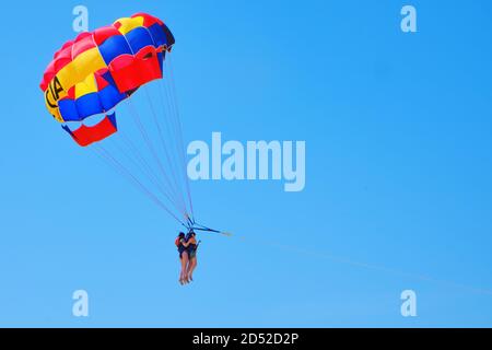 Tandem-Fallschirmspringer gegen den blauen Himmel - zwei Frauen in Tandem Stockfoto