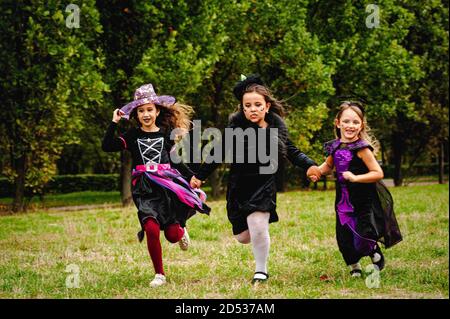 Kinder in halloween Kostümen laufen auf dem Rasen Stockfoto