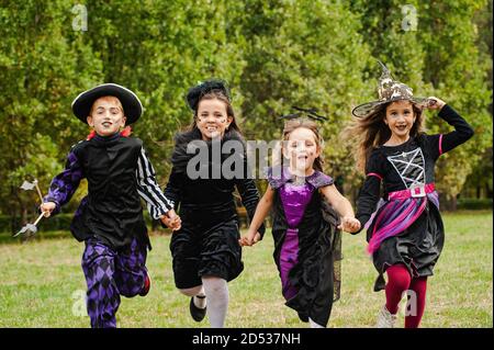 Kinder in halloween Kostümen laufen auf dem Rasen Stockfoto