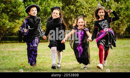 Kinder in halloween Kostümen laufen auf dem Rasen Stockfoto