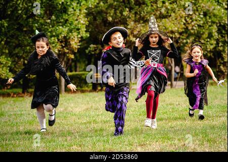 Kinder in halloween Kostümen laufen auf dem Rasen Stockfoto