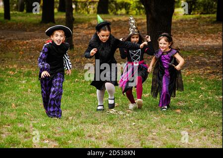 Kinder in halloween Kostümen laufen auf dem Rasen Stockfoto