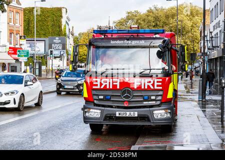 Ein Feuerwehrmann der Londoner Feuerwehr, der an einer Szene in der Islington High Street im Angel, London, Großbritannien, teilnimmt Stockfoto