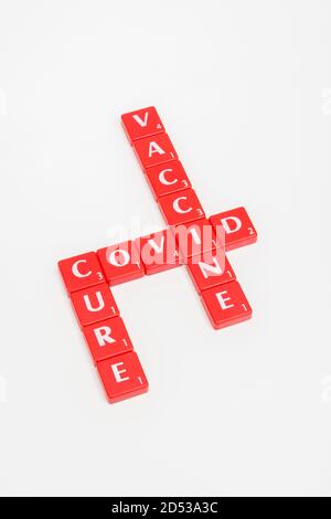 Kachelmatrix mit rotem Buchstaben für Covid 19, die Covid heilt, und Coronavirus/Covid-Impfstoff auf cremeweißem Hintergrund. Für den gefürchteten Covid 19. Stockfoto