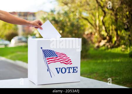 Geben Sie die Stimme in die Wahlurne auf dem Tisch draußen. Stockfoto