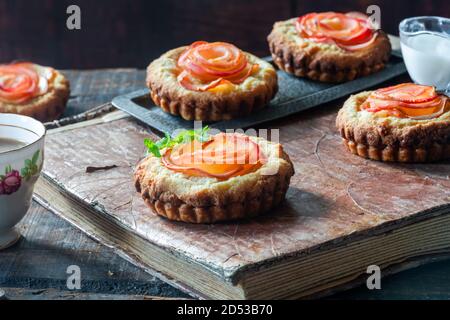 Mini Mandeltörtchen mit Apfelscheiben in einer Rose angeordnet Stockfoto