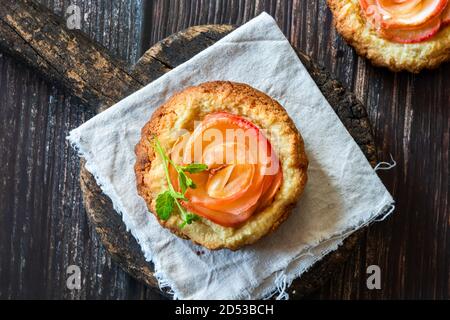 Mini Mandeltörtchen mit Apfelscheiben in einer Rose angeordnet Stockfoto