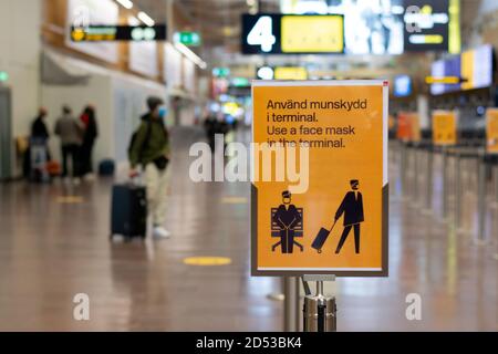 Konzentrieren Sie sich auf ein Schild mit dem Hinweis, dass Passagiere im Flughafen-Terminal in Schweden eine Gesichtsmaske tragen, um die Ausbreitung des Coronavirus zu verhindern. Stockfoto