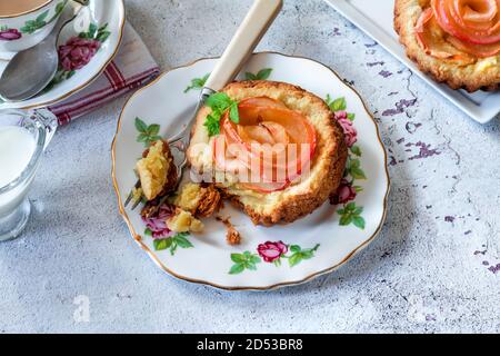 Mini Mandeltörtchen mit Apfelscheiben in einer Rose angeordnet Stockfoto