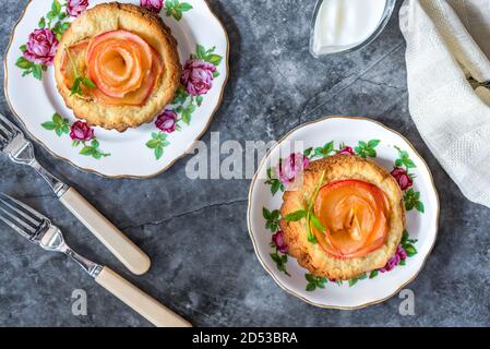 Mini Mandeltörtchen mit Apfelscheiben in einer Rose angeordnet Stockfoto