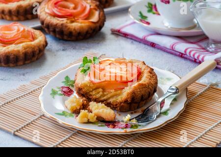 Mini Mandeltörtchen mit Apfelscheiben in einer Rose angeordnet Stockfoto