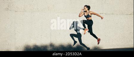 Fitnessmodell bei Kardiotraining am Morgen. Panoramahintergrund einer Fitness-Frau, die draußen läuft. Stockfoto