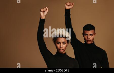 afroamerikanisches Paar in schwarzen Kleidern stehend, unterstützt schwarze Leben Materie Bewegung. Paar mit erhobenen Fäusten symbolisieren Kampf gegen oppressio Stockfoto