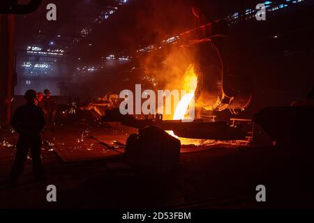 Metallgussverfahren in der metallurgischen Anlage. Flüssiges Metall in Formen gießen Stockfoto