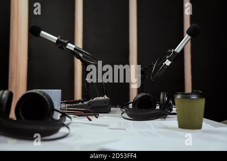 Arbeitsplatz des Radiohosts. Nahaufnahme von Mikrofonen, Kopfhörern und Tonmischpult auf dem Tisch im Aufnahmestudio oder Rundfunkraum Stockfoto