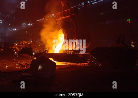 Metallgussverfahren in der metallurgischen Anlage. Flüssiges Metall in Formen gießen Stockfoto