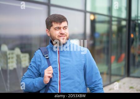 Bärtiger Tourist Mann mit Rucksack genießen Sie einen schönen Blick auf die moderne Stadt. Stockfoto